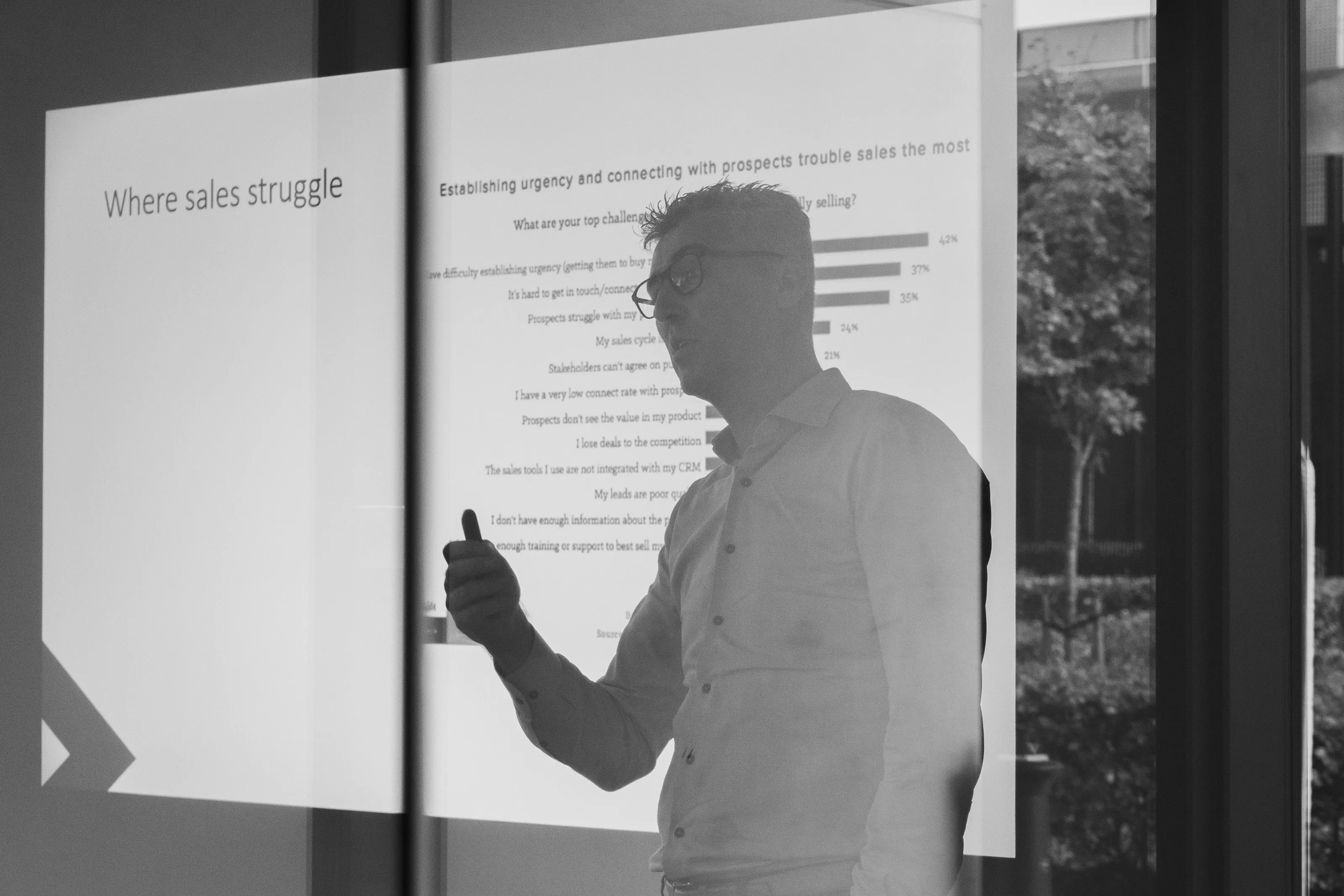 Two facilitators in conversation in front of a presentation screen